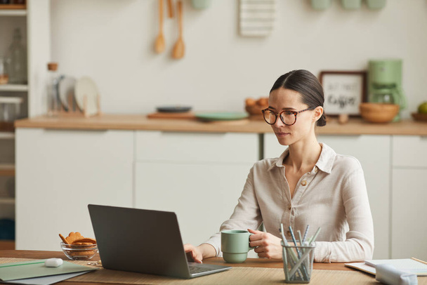 Portré elegáns fiatal nő kávézás közben laptop kényelmes otthoni irodai munkahely, másolás tér - Fotó, kép