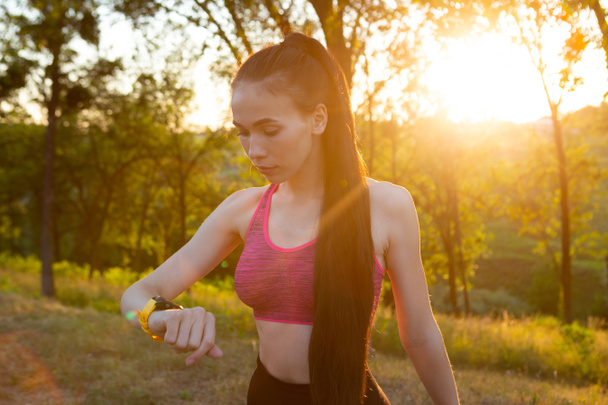 Femme vérifiant sa montre de fitness et son appareil portable de suivi de la santé - Photo, image