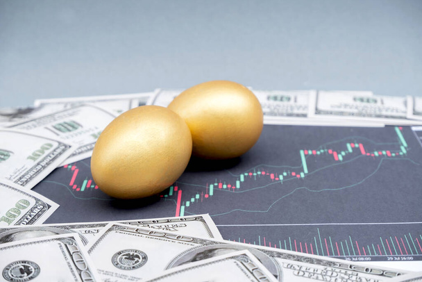 Der Bank-Dollar zusammen mit dem goldenen Ei und dem Aktiendiagramm, Ideen für Finanzwachstum und Geschäftserfolgsstrategien. - Foto, Bild