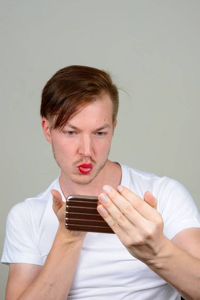 Studio shot van jonge Scandinavische man dragen van make-up - Foto, afbeelding