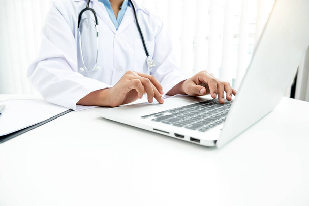 The female doctor sat and checked the patient's history and used a laptop to record patient information at the hospital. Medical concepts and interests. - Foto, Bild