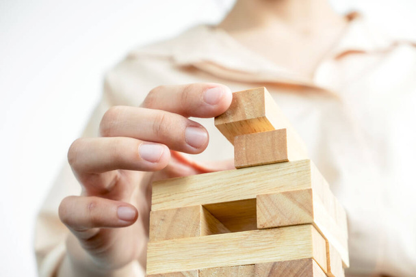Handen van zakenvrouwen die houten blokkenspel spelen. Concept Risico van management en strategieplannen voor groei en succes van bedrijven. - Foto, afbeelding