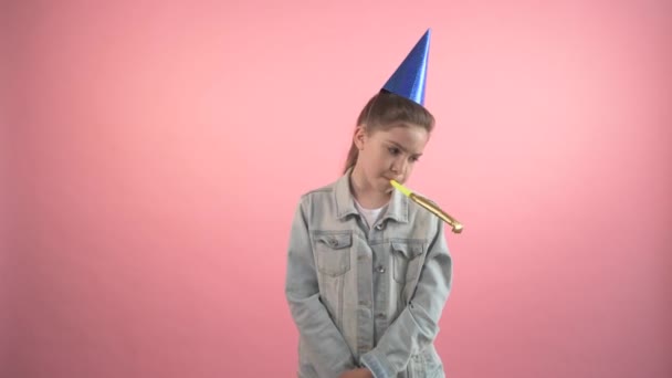Sad girl quarantines her birthday. In a cap and with a festive whistle. - Felvétel, videó