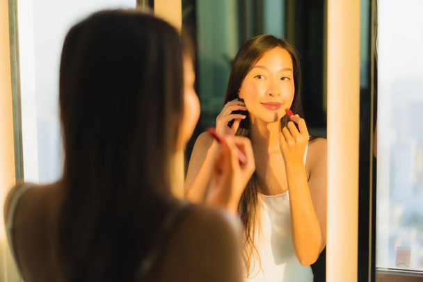 Portré gyönyörű fiatal ázsiai nő töltsük fel kozmetikai por és rúzs az arcán arc a fürdőszoba belső - Fotó, kép