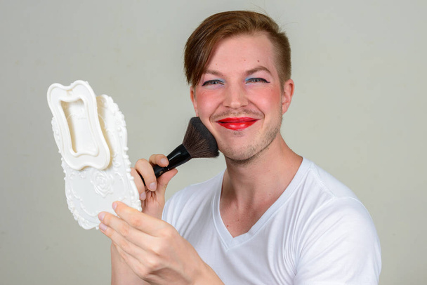 Studioaufnahme eines jungen skandinavischen Mannes mit Make-up - Foto, Bild