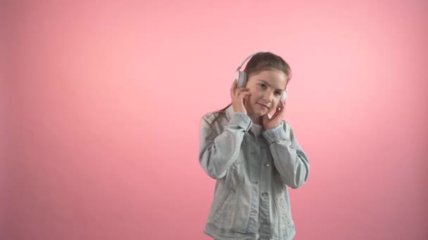 Beautiful happy girl listens to music on headphones and dances. - Video, Çekim