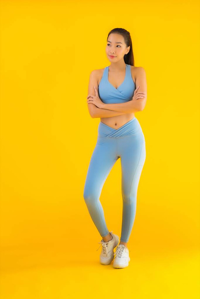Portrait beautiful young asian sport woman with sportwear ready for exercise on yellow isolated background - Fotoğraf, Görsel