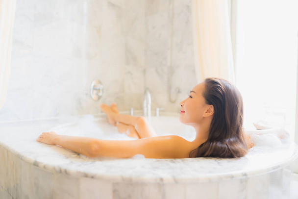 Портрет красива молода азіатка розслабляється прийняти ванну у ванній в інтер'єрі ванної
 - Фото, зображення