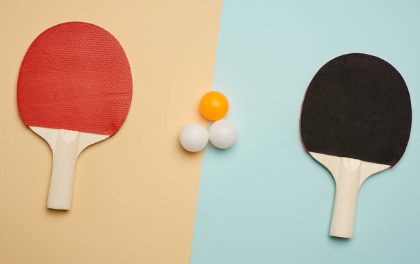 два деревянных ракетки и пластиковые мячи для игры в настольный теннис, плоский лежал, пинг-понг игры
 - Фото, изображение