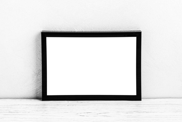 White wooden floor over concrete or decorative plaster wall and black photo frame with copy space for a text background. Mock up for design. - Photo, Image