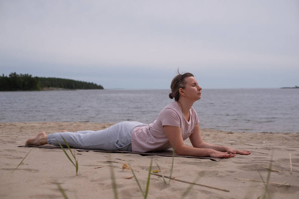 Femme faisant Cobra Yoga Stretch sur tapis de yoga - Photo, image