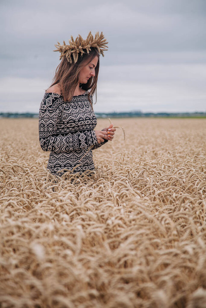 Piękna, szczupła dziewczyna na polu pszenicy na tle nieba deszczowego - Zdjęcie, obraz