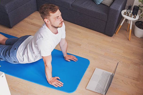 Young man doing yoga in his living room - Foto, imagen