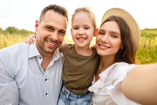 Ευτυχισμένη οικογένεια που βγάζει selfie σε υπαίθριο πικ-νικ - Φωτογραφία, εικόνα