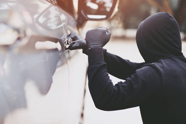 Злодій краде гаманець у машині
 - Фото, зображення