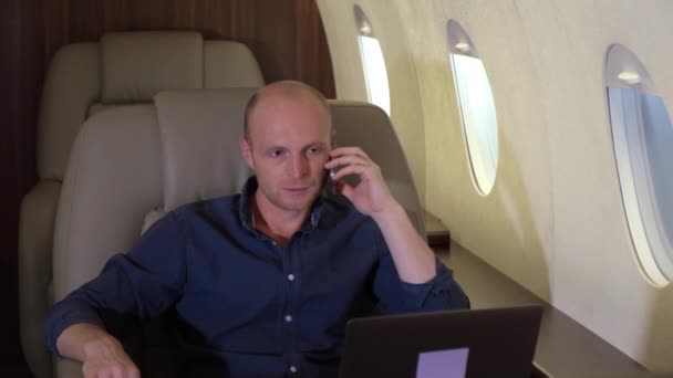 Portrét investora expert analytik muž pracující na notebooku v letadle Mluvení na telefonu - Záběry, video