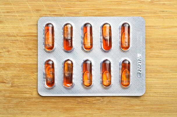 Orange Kapsel Pillen isoliert auf Holz Hintergrund, medizinische Kapsel Pillen - Foto, Bild