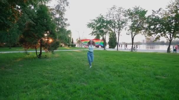 Woman running with rainbow flag, showing tolerance. - Materiał filmowy, wideo