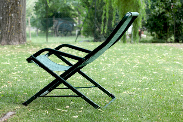 koncepcja relaksu: puste krzesło w ogrodzie o zachodzie słońca z kopią miejsca na tekst - Zdjęcie, obraz