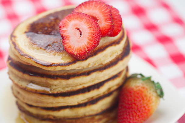 Pancakes, honey and strawberry on checkered fabric - Фото, зображення