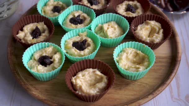 rauw deeg voor banaan cupcakes met chocolade in siliconen mallen, thuis muffins koken - Video