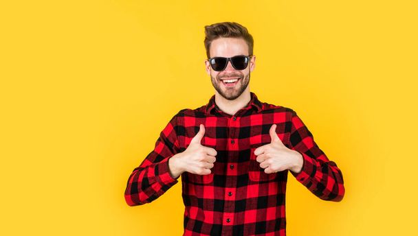 unshaven guy in casual style. male hairdresser and barbershop. male beauty trend. bearded man with sexy bristle in glasses. facial hair and skin care. handsome man wear checkered shirt. copy space - Valokuva, kuva
