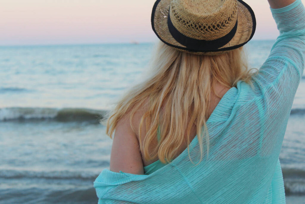 Nuori tyttö meren rannalla auringonlaskun aikana - Valokuva, kuva