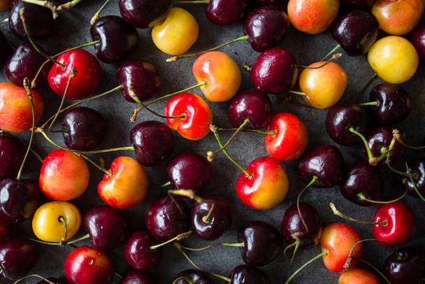 Juicy cherry close up photo. Water drops on fresh berries. Dark grey textured background. Healthy eating concept.  - Photo, image