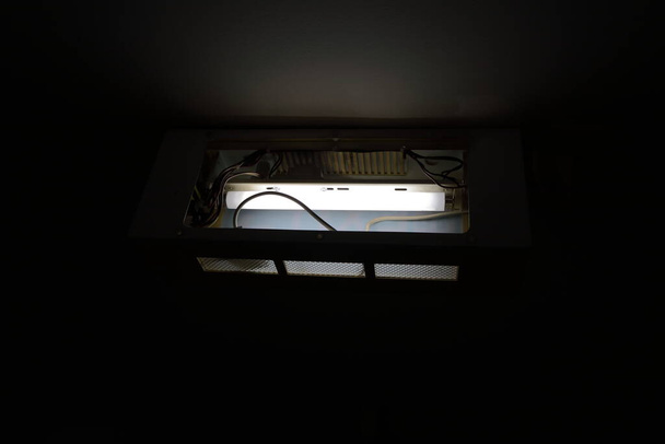 Closeup and selective focus of fluorescent lamp inside exposed exit sign box attached to ceiling, rear view   - Photo, Image