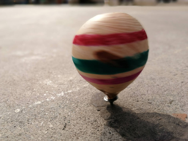 wooden spinning top while spinning on the ground - Photo, Image