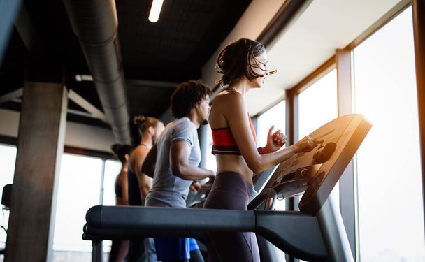 Group of young people running on treadmills in modern sport gym - Valokuva, kuva