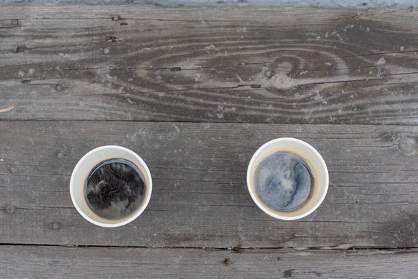 Dos vasos de papel con café. Café americano o expreso sobre fondo de madera. Mañana y alegría
 - Foto, imagen