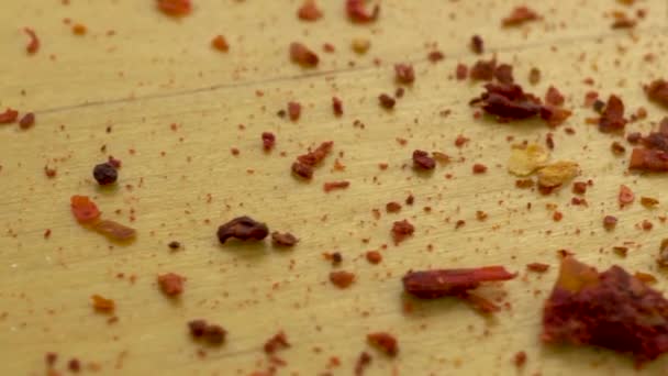 Gemalen chili pepers op een houten ondergrond. Verplaatsen platform met peper macro shot. - Video