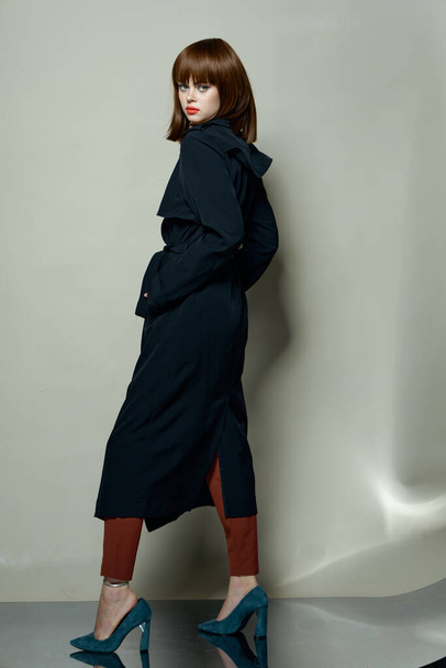 brunette woman in a black coat and high heel shoes - Foto, Imagem