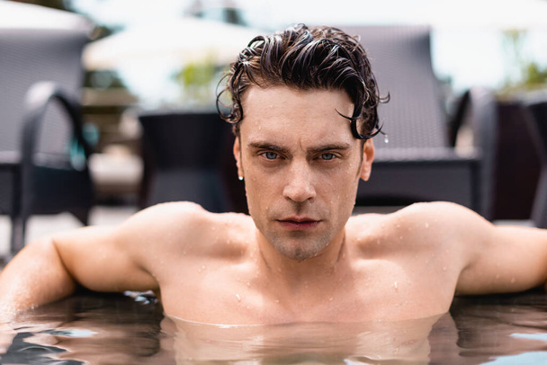 wet and handsome man looking at camera in swimming pool  - Foto, Imagem