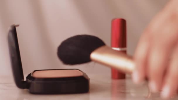 Productos de maquillaje elegantes en mesa de mármol, polvo, lápiz labial y pincel como fondo para la marca de cosméticos y belleza
 - Metraje, vídeo