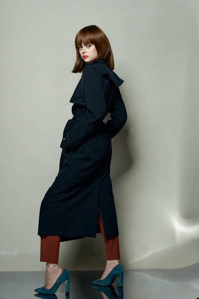 Fashionable woman in a black coat model high heel shoes free place - Foto, imagen