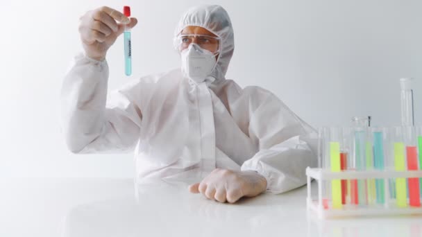 Scientist in PPE holding vaccine against infection disease and showing thumb up - Felvétel, videó