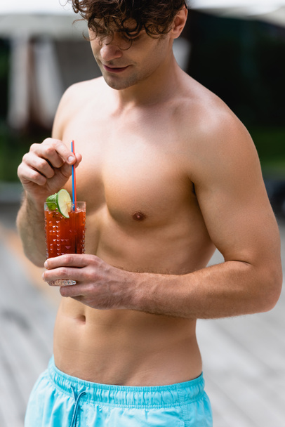 handsome and shirtless man holding glass with cocktail  - Photo, image