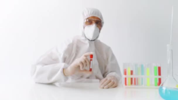 Doctor in PPE showing covid 19 infected blood sample test tube - Imágenes, Vídeo