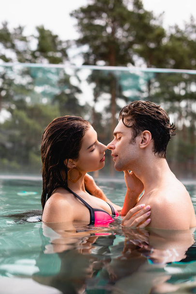 side view of couple with closed eyes in swimming pool - Фото, зображення