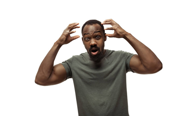 Young african-american man with funny, unusual popular emotions and gestures isolated on white studio background - 写真・画像
