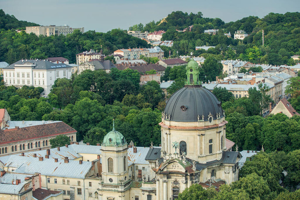 Ukrayna 'da yaz aylarında Dominik katedrali ve diğer Lviv tarihi binaları ve yeşil ağaçların hava manzarası - Fotoğraf, Görsel