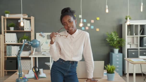 Portrait of joyful business lady smiling holding glasses in modern creative office - Materiaali, video
