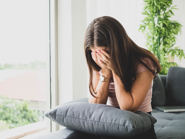 young attractive and sad woman sitting depressed at home sofa couch feeling anxious and frustrated suffering depression problem, Lonely sad woman and cry in her room. - Photo, Image