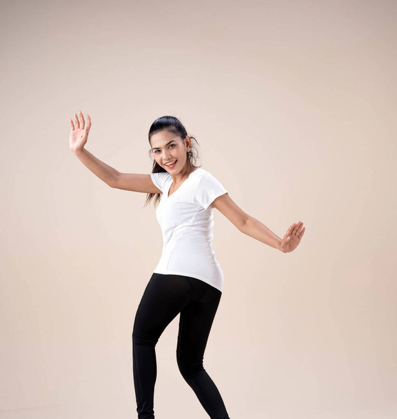 Nuori kaunis nainen seisoo jalat aparts, nostaa handsup ilmassa, vähän kierretty, tanssi harjoitus liikuntaan, jossa onnellinen tunne - Valokuva, kuva