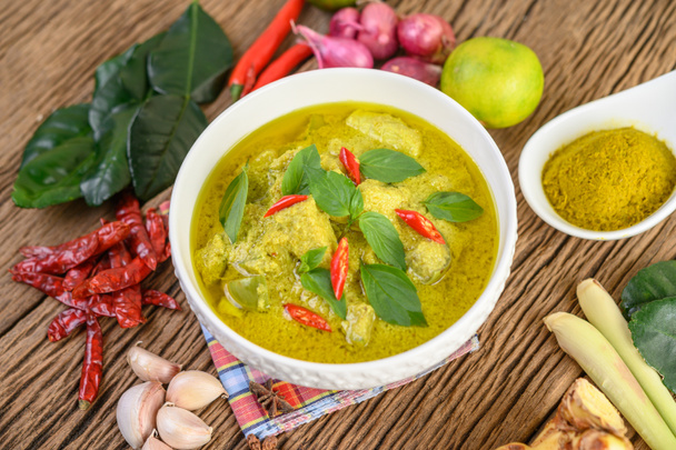 Curry vert dans un bol et épices sur table en bois. - Photo, image