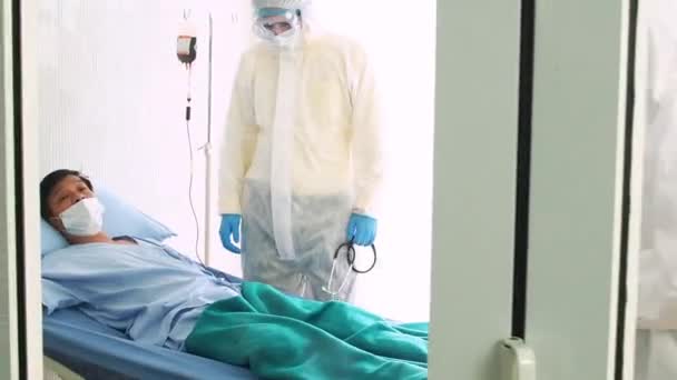 O médico cuida de um paciente doente, tossindo de coronavírus na cama do hospital. homem doente em uma cama de hospital
. - Filmagem, Vídeo
