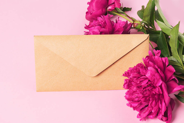 郵便封筒美しいブルゴーニュ牡丹。花の背景トップビューのフラットレイアウト。新鮮な花のフレーム。休日の概念。グリーティングカードのテキストコピースペースのテンプレート. - 写真・画像