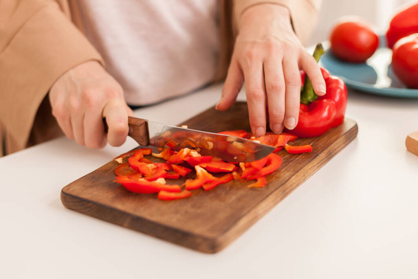 Close up of hand slicing pepper - 写真・画像